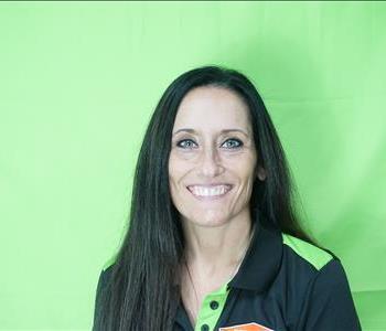 Female employee with black hair in front of green background