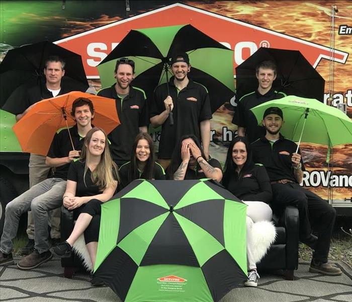 Team photo with umbrellas in SERVPRO uniform