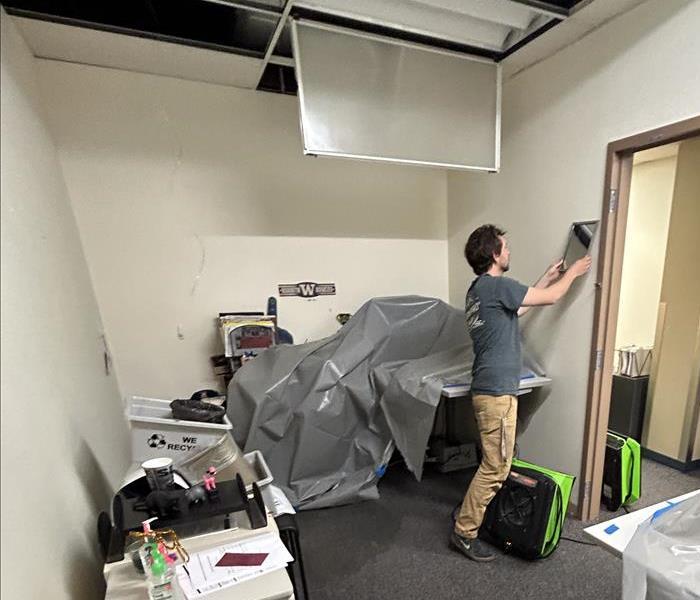 A technician cleaning damage left behind by a commercial water damage